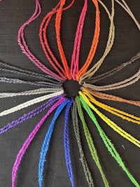 a bunch of colorful threads arranged in a circle